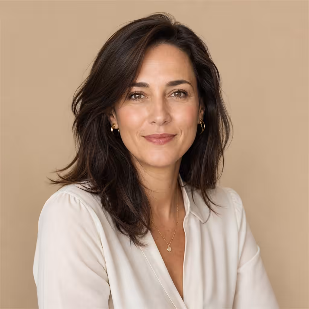 Femme souriante en chemise blanche, fond beige.