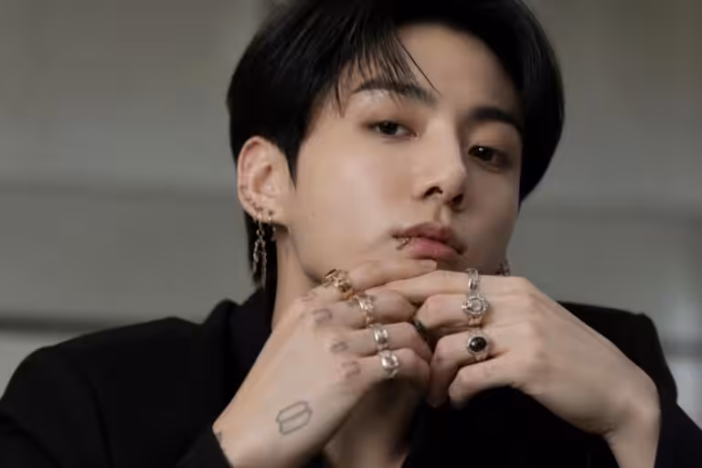 découvrez comment jung kook de bts révolutionne le style bijoux avec ses boucles d’oreilles et multiples bagues, adoptant un look audacieux et éclectique.